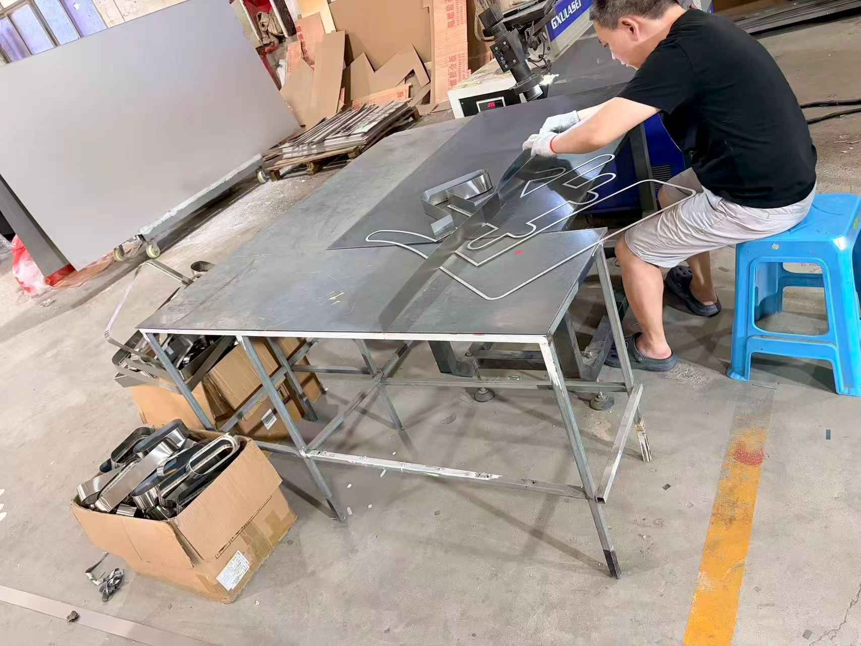 Measuring and finishing custom metal signs. Attention to detail in the final stages of production before delivery
